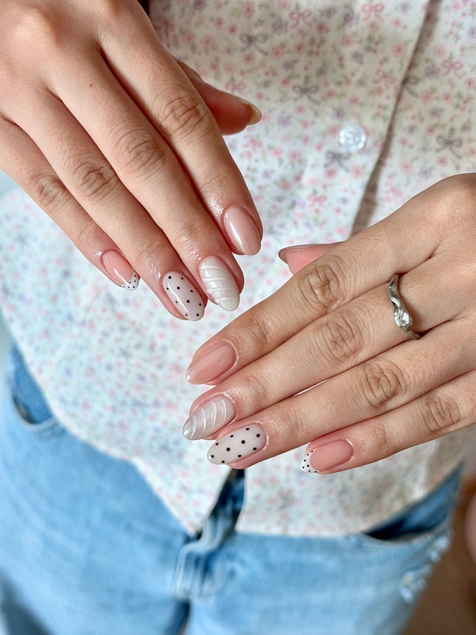 Nude nails with black polka-dot accents